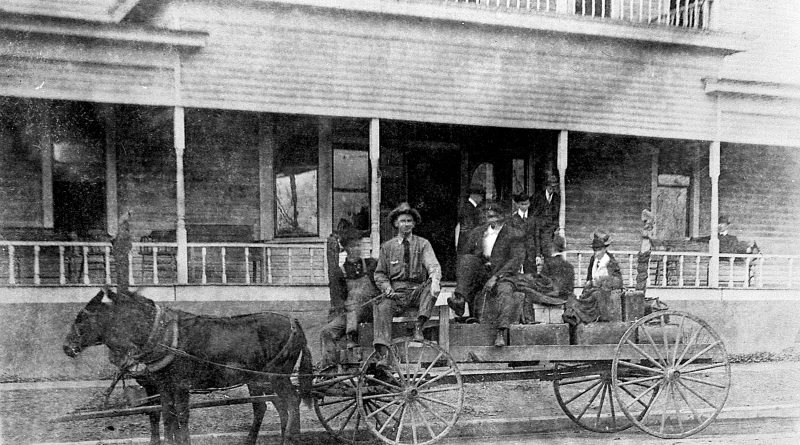 Ewell McClinton and Chancellor Edwards in wagon in front of the Pleasant Hotel